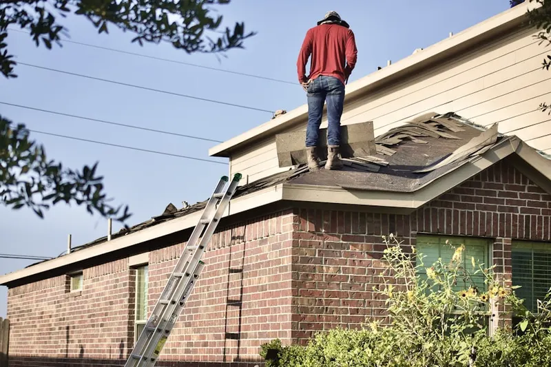 Professional roofer working on a residential roof in George Mason
